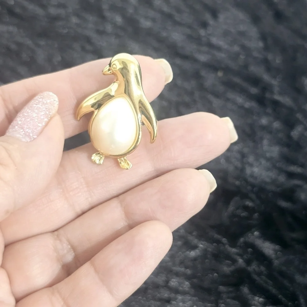 Monet Jewelry Two gold-tone leaf and penguin brooches